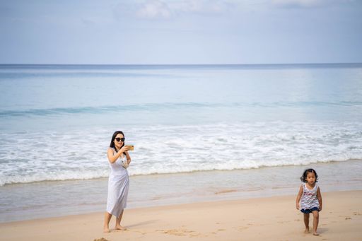 A young Asian mother and her daughter playing on a seashore