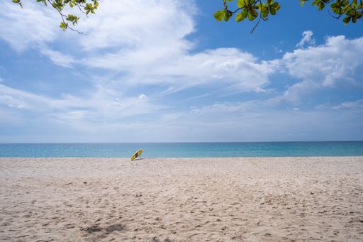 A closeup shot of a sandy beach with a tranquil sea