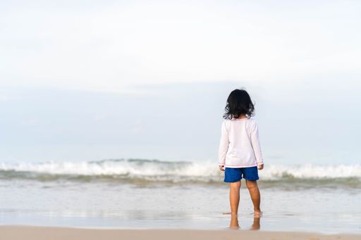 A little girl playing at the seashore in Phuket Thailand.
