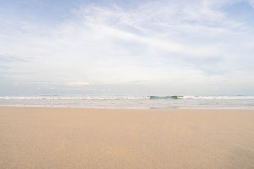 A high angle shot of a sandy beach with beautiful seascape and skyline melded together