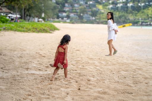 A little girl and her mother walking on the beach in Phuket
