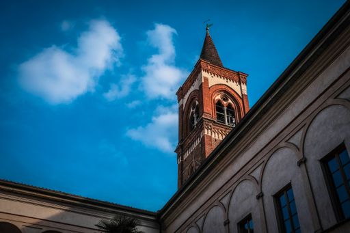 A low angle shot of a bell tower with blue sky in the background at daytime