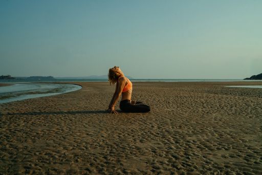 A great shot of a fit Caucasian girl doing yoga on the beach in Ukraine