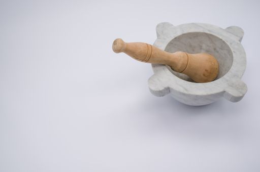 A high angle shot of mortar and pestle isolated on a gray background