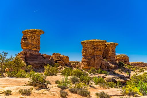 Stunning rock formations under a vibrant blue sky in Canyonlands National Park, Utah, showcasing natural beauty and geological wonder.