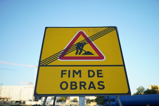 A yellow sign saying 'End of road work' in Portuguese