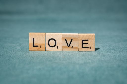 Wooden letters spelling 'love' on a greenish background