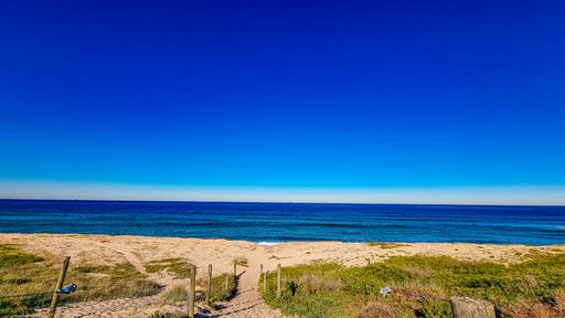 An empty white sand beach under the blue clear sky