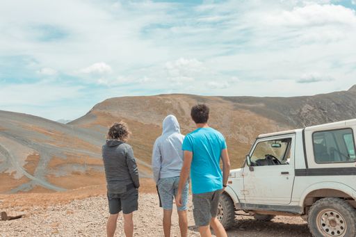 A beautiful view of the roads in the hills and a group of people near the car in Andorra