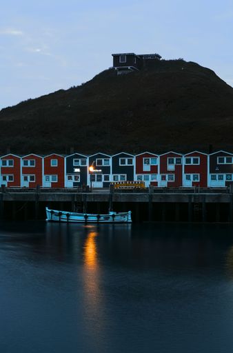 Colorful Hummerbuden at Helgoland harbor with a white boat at dusk