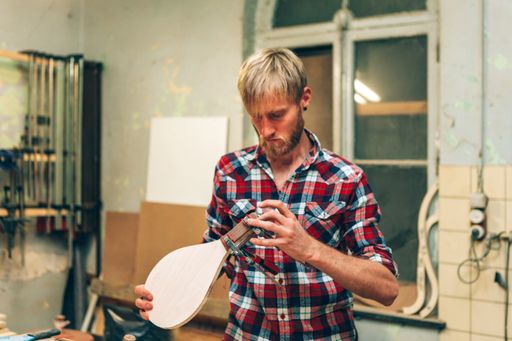Young carpenter doing paddle racket at his workshop studio