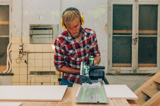 Designer artisan man working with wood while using mowing saw