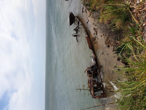 A vertical shot of HMAS Parramatta Shipwreck in the water on a cloudy day.
