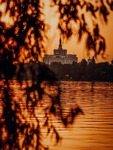 A beautiful tower building behind the lake during sunset
