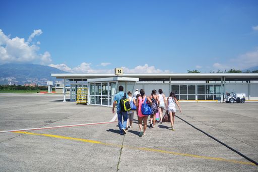 A group of tourists in the airport during a sunny day