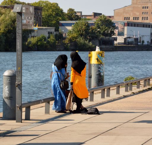 Two women in hijab walking in the riverside