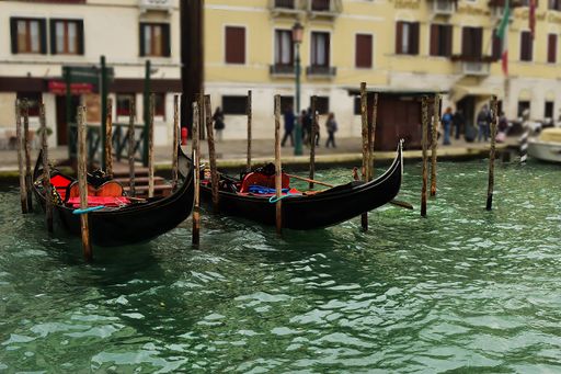 the Two empty and unattended gondolas, parked next to a pier or jetty, Venice, Italy