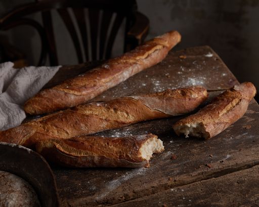 A closeup shot of freshly baked baguette on a wooden board