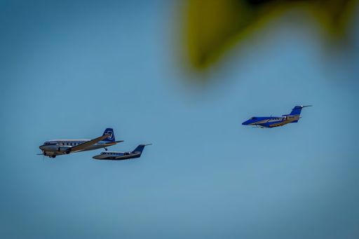 Vintage airplanes in formation flight against a clear blue sky