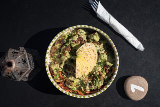 A top view closeup of a typical Moroccan food bowl, utensils and a stone with a number on it