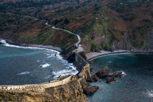 An aerial shot of the scenic bridge connecting San Juan de Gaztelugatxe islet with the mainland, Bermeo, Basque Country, Spain