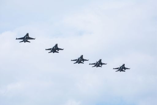 Five military aircraft flying in formation against a cloudy sky