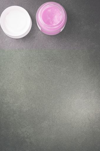 A top view of skin care cream container on a stone surface with free space for text