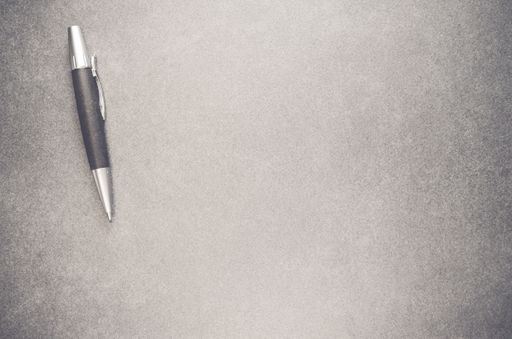 A pen isolated on a grungy grey background with free space for text