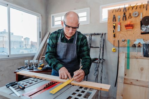 A senior Caucasian carpenter working in his room