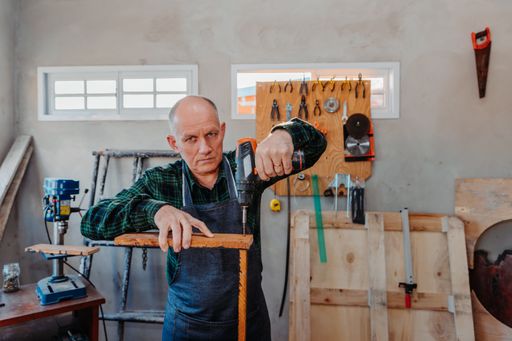 A senior Caucasian carpenter working in his room