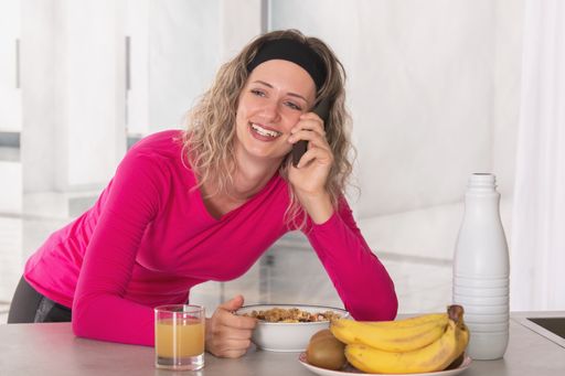 Breakfast with cereals and fruits to start the morning with lots of energy. Smiling woman having breakfast.