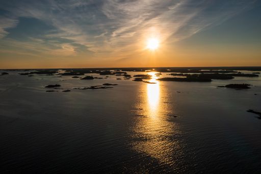 Aerial view overlooking sunlit islands, serene, summer evening, in Ekenas Archipelago national park, Raasepori, Finland