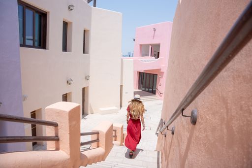 girl with a red dress walking on the Colorful Streets in Mina District Corniche, Doha Marina, Doha, Qatar