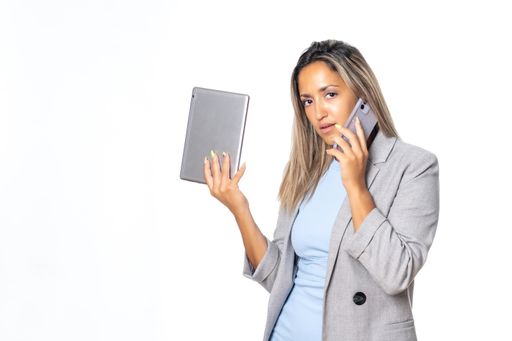 A business woman talking on the phone while holding a tablet with the white background