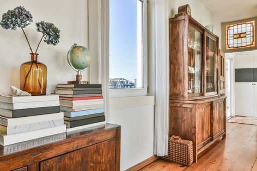 A closeup shot of stacked books and a globe on a vintage dressing table