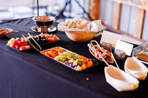 A vibrant buffet table with assorted fruits, vegetables, and breads arranged for a casual dining event.