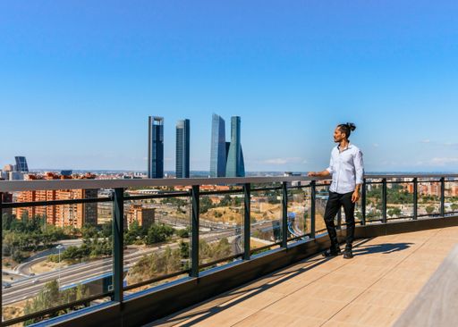 Businessman on the roof of a building looking at the city and the district skyscrapers in Madrid Spain
