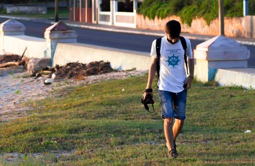 A photographer walking on the grass in the park