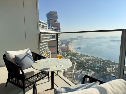 Luxurious balcony in Dubai with cocktails overlooking a marina on a sunny day