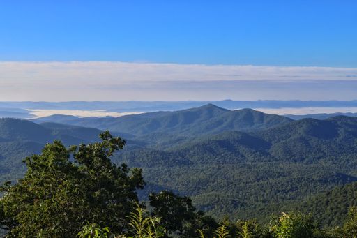 A beautiful view of the mountain chain in the background covered in forests on a sunny day