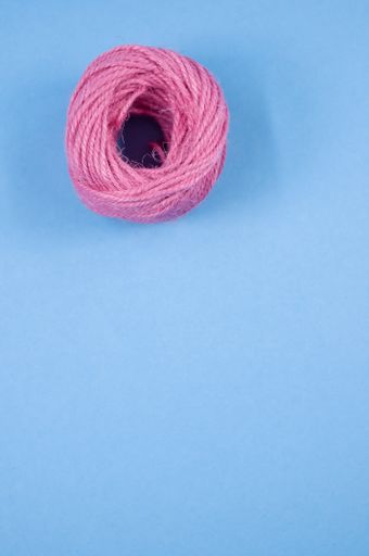 A top view of a colorful thread rope yarn on a blue background