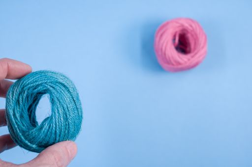A top view of a colorful thread rope yarn on a blue background