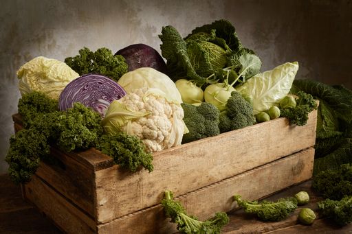 A closeup shot of Chinese and Savoy cabbages with cauliflower and broccoli in a wooden box