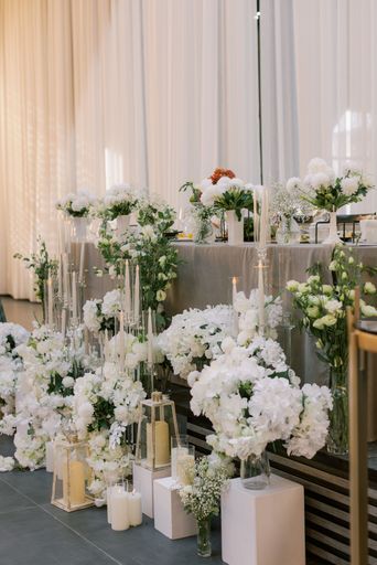 Elegant wedding table decor with white flowers and candles, creating a romantic atmosphere.