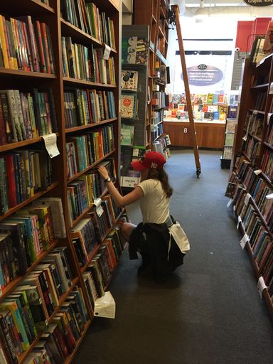 A girl looking through the books at a Harvard Book Store in Boston