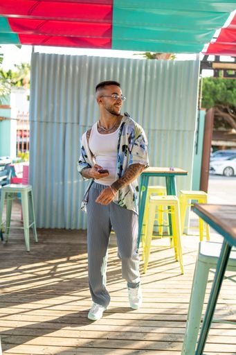 A vertical shot of a white Caucasian guy posing for a photoshoot in a cafe