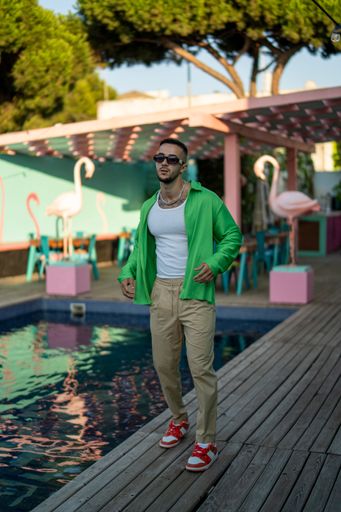 A vertical shot of a white Caucasian guy posing for a photoshoot in the pool