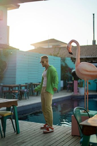 A vertical shot of a white Caucasian guy posing for a photoshoot in the pool