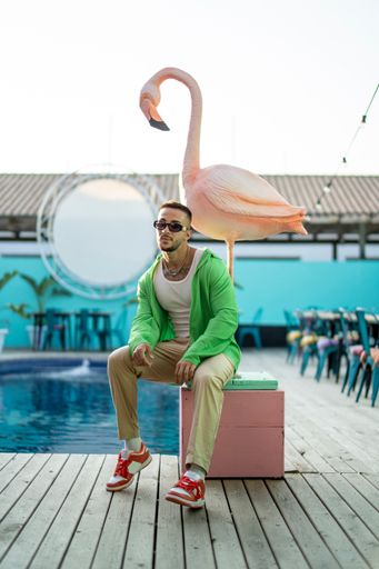 A vertical shot of a white Caucasian guy posing for a photoshoot in the pool