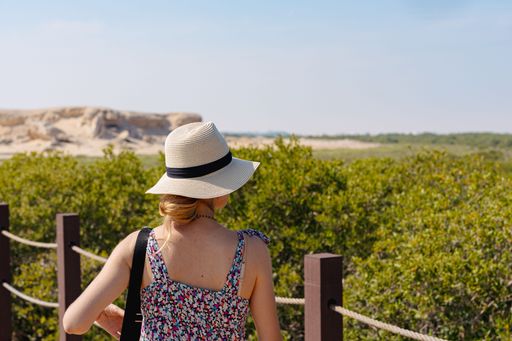 female tourist visiting the mangroves, Purple Island, in Qatar during the day